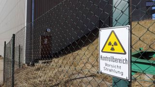 Teil des Kernkraftwerkes Rheinsberg - an einem Maschendrahtzaun hängt ein Schild mit der Aufschrift "Kontrollbereich - Vorsicht Strahlung" (Bild: picture alliance / ZB)