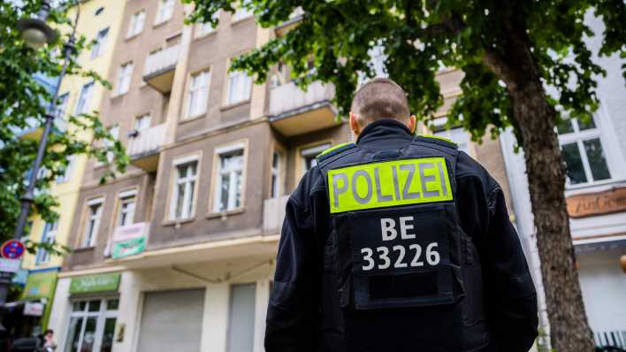 Ein Polizist steht bei einer Hausdurchsuchung gegen die Gruppe "Letzte Geneartion" in Berlin-Kreuzberg vor einem Gebäude. (Bild: dpa)