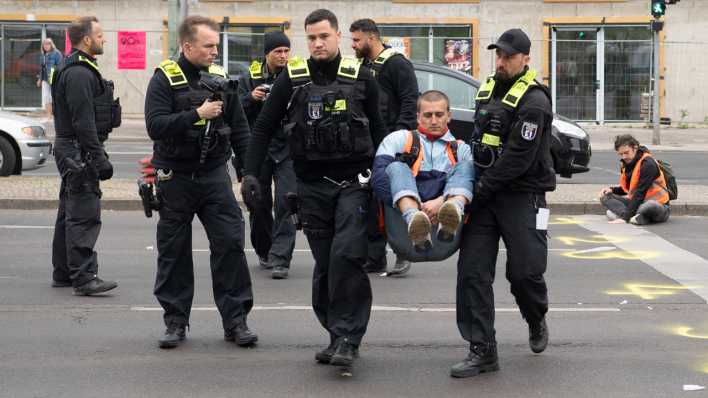 Berlin: Polizeikräfte tragen bei einer Straßenblockade der Letzten Generation einen Aktivisten von der Straße
