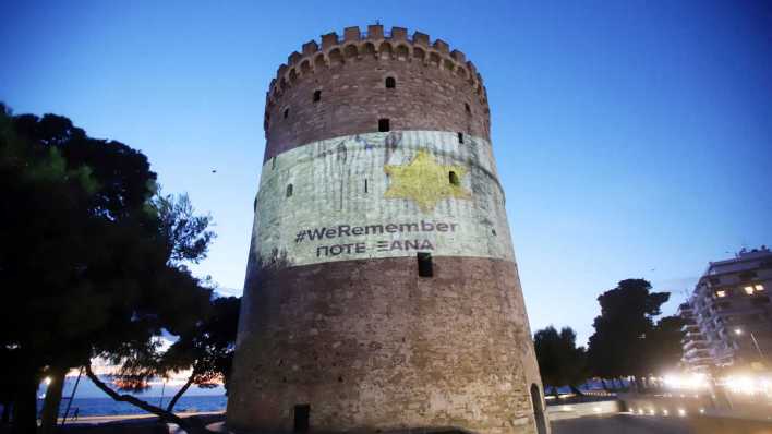 27.1.2023: Der Weiße Turm, Wahrzeichen der Hafenstadt Thessaloniki, Griechenland, ist anlässlich des internationalen Holocaust Gedenktages mit dem sog. "Judenstern" und dem Schriftzug # We REMEMBER, POTE XANA (Nie wieder) angestrahlt (Bild: picture alliance / ANE / Eurokinissi)