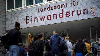 Wartende Menschen stehen vor dem Landesamt fuer Einwanderung in Berlin