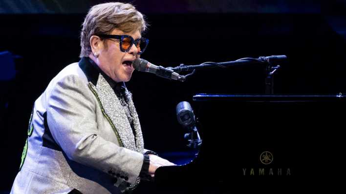Der Sänger und Pianist Elton John sitzt bei einem Konzert im Rahmen seiner "Farewell Yellow Brick Road Tour 2023" auf der Bühne.