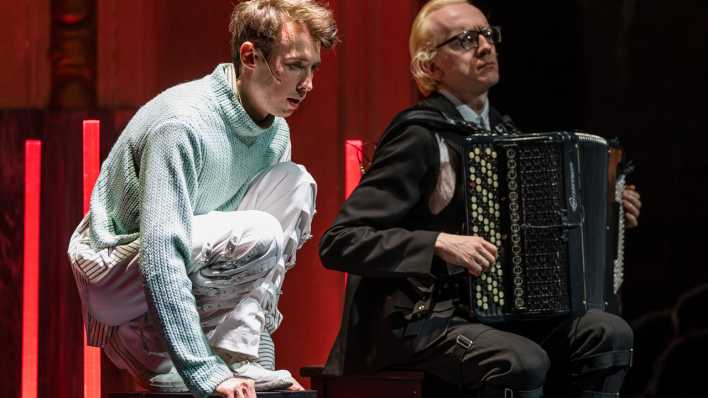 Der Schauspieler Torben Appel (Alan) und Live-Musiker Aliaksandr Yasinski sitzen auf der Bühne des Staatstheaters Cottbus bei einer Fotoprobe für den Thriller "Equus" von Peter Shaffer