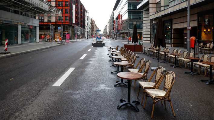 Cafétische und Stühle stehen auf der für den Autoverkehr gesperrten Friedrichstraße (Bild: picture alliance / Jochen Eckel)