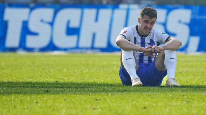 Herthas Marc-Oliver Kempf sitzt nach dem Schlusspfiff vor dem Schriftzug "Tschüss" auf dem Rasen.