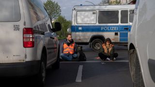Aktivisten der Gruppierung Letzte Generation blockieren eine Kreuzung an der Landsberger Allee.