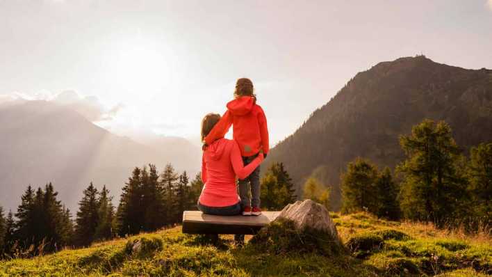 Eine Mutter und ihre Tochter genießen den Ausblick auf die Berge.