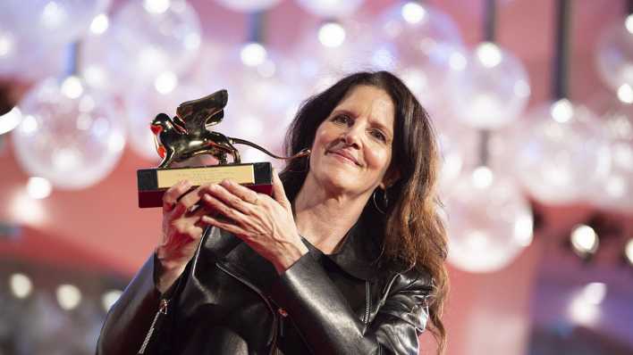 Laura Poitras mit ihrem Goldenen Löwen, der ihr 2022 beim Film Festival in Venedig für "All the Beauty and the Bloodshed" verliehen wurde. _foto: picture alliance/Stringer/Anadolu Agency