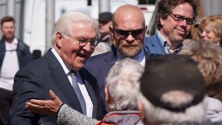 Bundespräsident Frank-Walter Steinmeier (SPD) wird nach seiner Ankunft in Senftenberg auf dem Marktplatz von Schaulustigen begrüßt.