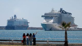 Menschen spazieren an der Meerespromenade in der Nähe von Kreuzfahrtschiffen