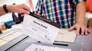 Ein Bürger wirft in einem Wahllokal im Stadtteil Vegesack seinen Stimmzettel für die Bürgerschaftswahl in eine Wahlurne.