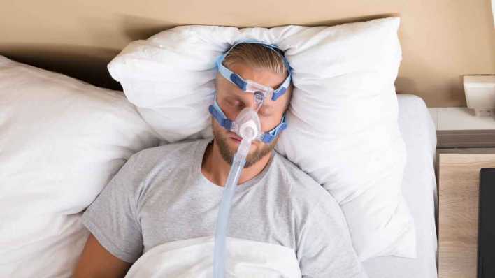 Mann mit Atemstörung trägt CPAP Maske im Schlaf (Bild: imago images/Panthermedia)