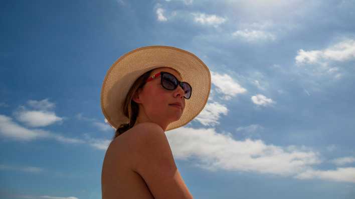 Junge Frau mit Sonnenbrille und Hut