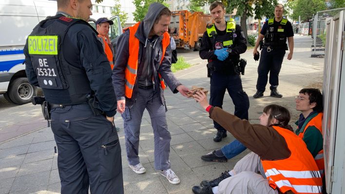 Polizei bewacht Demonstranten Hannah und Markus der "Letzten Generation"