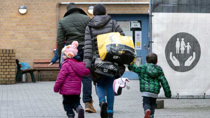 Eine geflüchtete Familie geht über das Gelände der Erstaufnahmeeinrichtung des Landesamtes für Flüchtlingsangelegenheiten (LAF) in Reinickendorf.