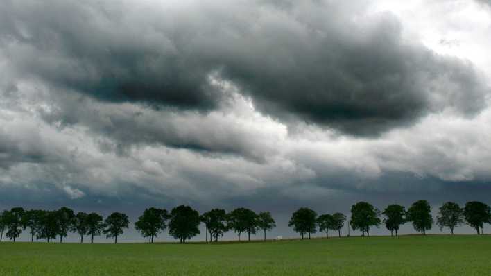 Dicke, dunkle Regenwolken über einer Landstraße nahe Müncheberg (Landkreis Märkisch-Oderland).