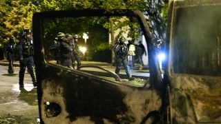 Polizisten gehen an abgefackelten Autos in Nanterre, außerhalb von Paris vorbei