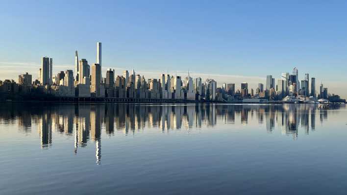 Die Skyline von Manhattan spiegelt sich im Wasser. (Quelle: Picture Alliance)