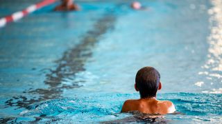 Ein Junge schwimmt in einem Becken. (Quelle: Picture Alliance)