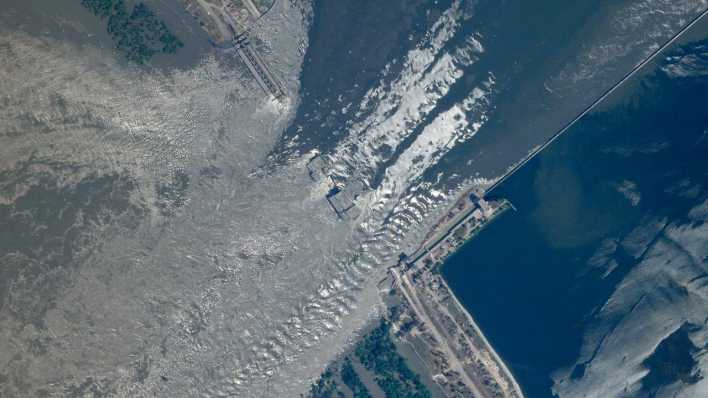 Ein Satellitenbild zeigt die Bruchstelle des Kachowka-Damms im Süden der Ukraine. (Quelle: picture alliance/dpa/Planet Labs PBC/AP | Uncredited)