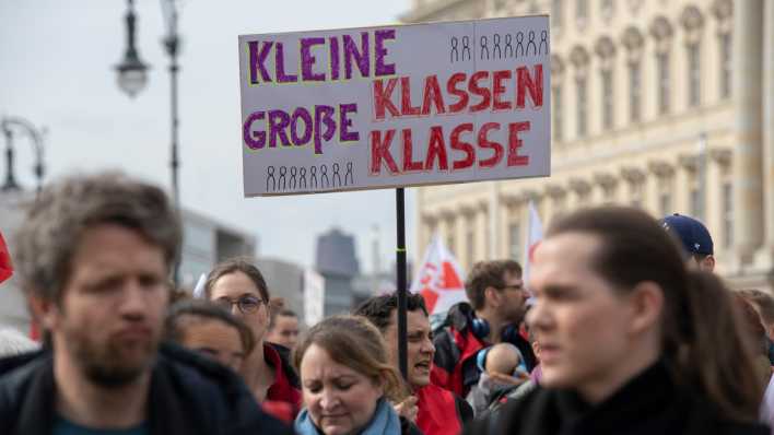 Lehrkräfte nehmen an einem Warnstreik in Berlin teil und halten ein Plakat mit der Aufschrift "Kleine Klassen - große Klasse" hoch