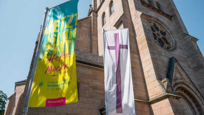 Eine Fahne des Deutschen Evangelischen Kirchentags und die Kirchenfahne der Evangelischen Kirche hängen vor der St. Paul Kirche in Nürnberg.