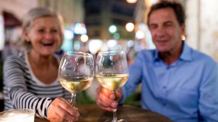 Älteres Paar stößt mit Wein an