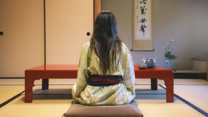 Frau in Japan sitzt auf dem Boden an einem Tisch