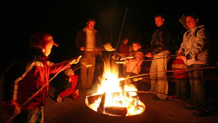 Menschen grillen an einem Lagerfeuer