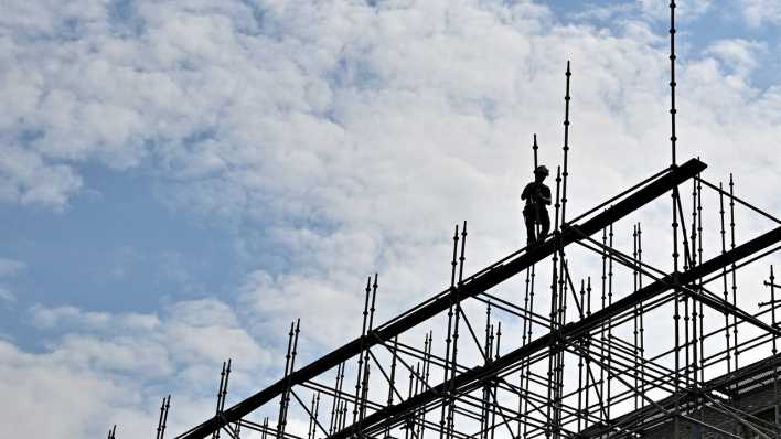 Bauarbeiter auf einem hohen Baugerüst
