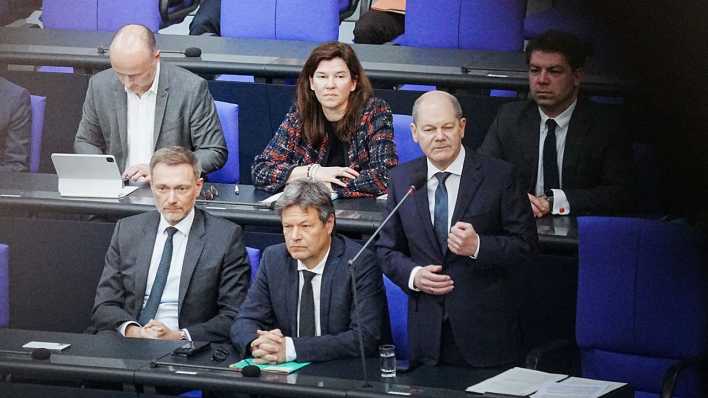 Bundeskanzler Olaf Scholz (SPD, 2.v.r) spricht im Bundestag bei der Befragung der Bundesregierung neben Christian Lindner (FDP, l), Bundesminister der Finanzen, und Robert Habeck (Bündnis 90/Die Grünen, M), Bundesminister für Wirtschaft und Klimaschutz,