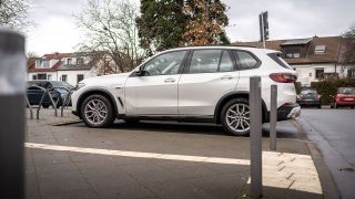 Ein Großes SUV steht auf einem Anwohnerparkplatz.