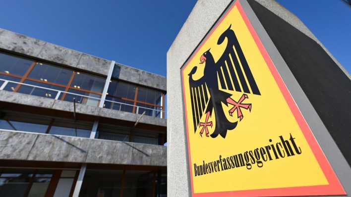 Vor dem Bundesverfassungsgericht hängt ein Hinweisschild mit der Aufschrift Bundesverfassungsgericht und dem Bundesadler.