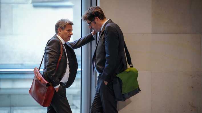 Robert Habeck, Bundesminister für Wirtschaft und Klimaschutz, und Michael Kellner, Grüner Staatssekretär im Bundeswirtschaftsministerium, unterhalten sich während einer Sitzung des Bundestags (Bild: dpa / Kay Nietfeld)