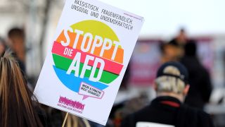 Teilnehmer mit Anti AfD-Plakaten stehen bei Gegendemonstration auf dem Domplatz in Magdeburg