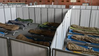 In einer Turnhalle stehen Feldbetten mit Schlafsäcken auf dem Gelände der Zentralen Erstaufnahmeeinrichtung für Asylbewerber (ZABH) des Landes Brandenburg.