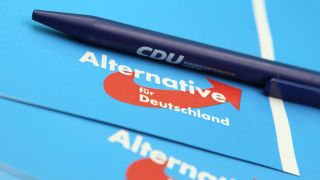 Ein Kugelschreiber der CDU liegt auf einer Infobroschüre der AfD.