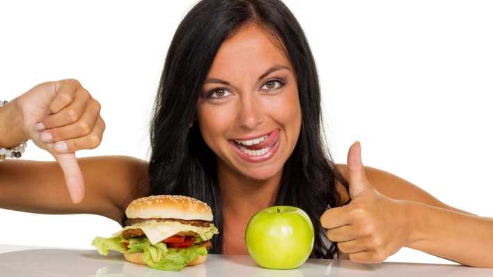 Junge Frau mit Hamburger und Apfel