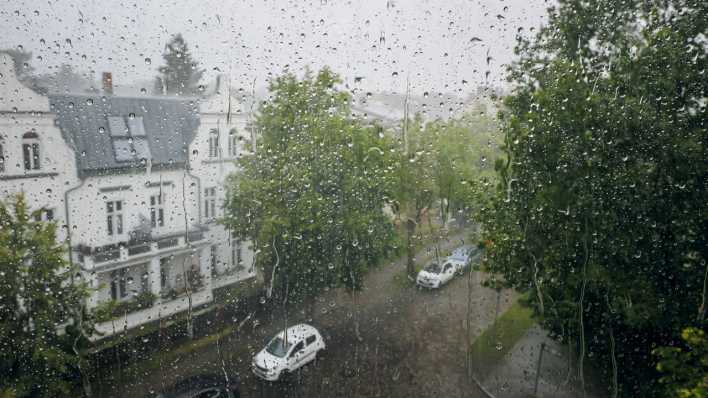 Regentropfen hängen an einer Fensterscheibe während eines Gewitters in Berlin