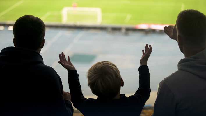 Ein Junge wirft bei einem Fußballspiel enttäuscht die Arme in die Luft.