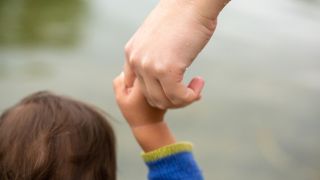Symbolbild: Eine Mutter hält ihr Kind an der Hand