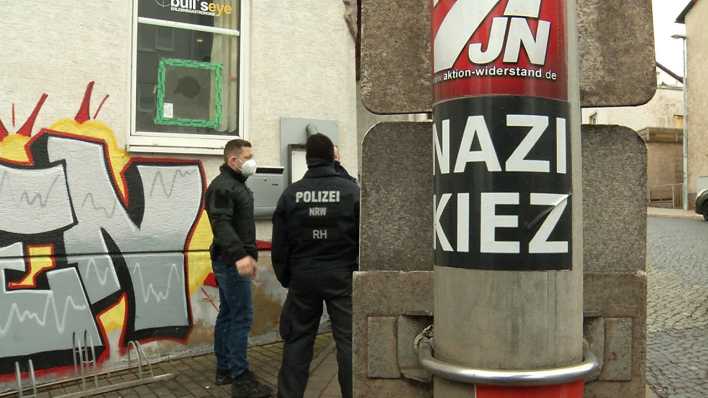 Polizisten stehen vor der Gaststätte "Bull's Eye" in Eisenach. An einem Pfahl ist ein Aufkleber mit der Aufschrift "Nazi Kiez" zu sehen. (Archivbild)