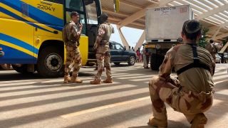 Französische Soldaten stehen im Niger neben einem Bus, der französische Staatsangehörige zum Flughafen bringt.