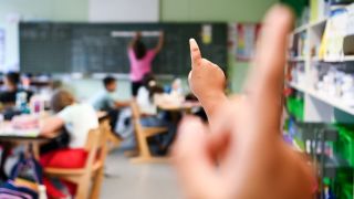 Schülerinnen und Schüler melden sich im Unterricht.