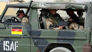 Mit dem Maschinengewehr schussbereit in der Hand fahren Bundeswehrsoldaten 2003 in einem Militärgeländewagen vom Typ "Wolf" in den Straßen von Kabul. (Bild: picture alliance/ dpa)