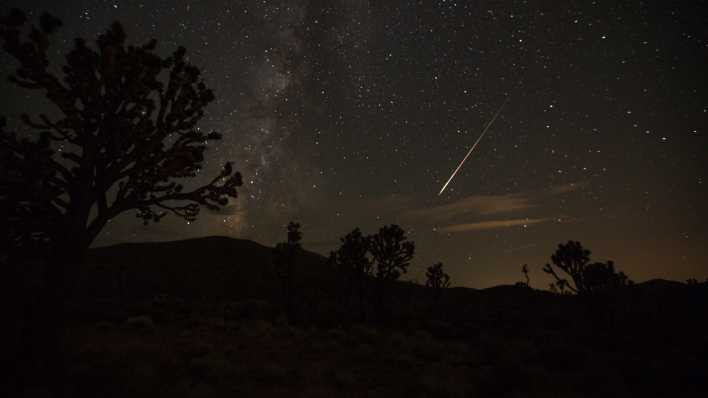 Eine Sternschnuppe aus dem Sternschnuppenstrom der Perseiden erzeugt über der Mojave-Wüste in den USA einen Streifen am Himmel (Bild: Richard Brian/Las Vegas Review-Journal/AP/dpa)