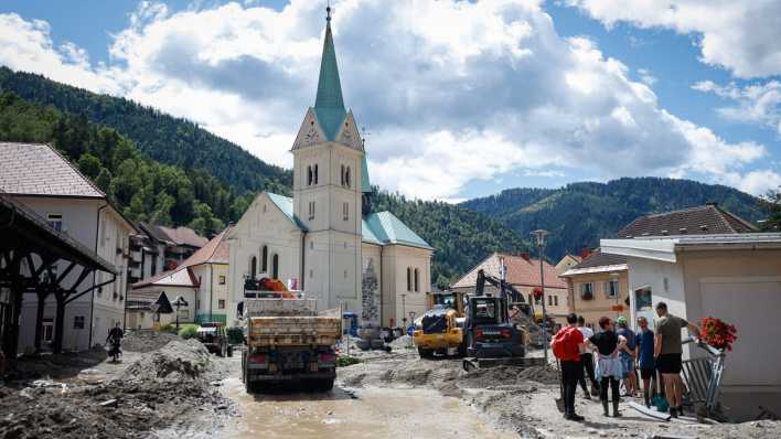 Menschen beobachten die Räumungsarbeiten in Slowenien.