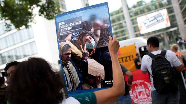 Eine Demonstrantin hält im August 2022 in Berlin ein Plakat mit der Aufschrift "Die Vergessenen retten" hoch. (Archivbild)