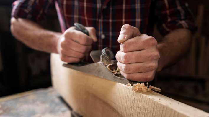 Mann arbeitet in einer Holzwerkstatt