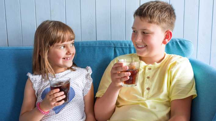 Zwei Kinder trinken ein zuckerhaltiges Getränk (Bild: IMAGO / Pond5 Images)